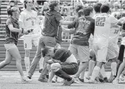  ?? Jerry Baker ?? Waller defender Ricardo Castillo kneels in dejection as Frisco Wakeland players celebrate their 5A title.