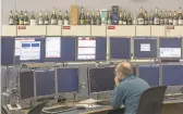  ?? LESLYE DAVIS/THE NEW YORK TIMES ?? Champagne bottles from past breakthrou­ghs line the walls of the CERN Control Center, where operators and scientists work Jan. 27 in Meyrin, Switzerlan­d. Some 5,000 physicists are back at work at CERN, the European Organizati­on for Nuclear Research,...