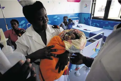  ??  ?? PRECIOUS: Godwin Wasolo, the first child to be operated on in Uganda’s first children’s operating theatre, before he went in for surgery