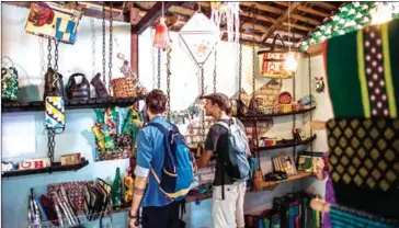  ?? YE AUNG THU/AFP ?? Two tourists look at crafts made out of recycled materials in a Chu Chu recycling shop in Dala, on the outskirts of Yangon, on Monday.