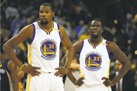  ?? Stephen Lam / Special to The Chronicle ?? Kevin Durant (left) and Draymond Green pause in the first half of Friday’s loss to the Grizzlies. When Durant made a play near the end of regulation that Green thought could have been better, Green didn’t hide his displeasur­e.