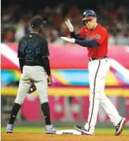  ?? AP PHOTO/BEN MARGOT ?? The Atlanta Braves’ Freddie Freeman, right, celebrates beside the Miami Marlins’ Jazz Chisholm Jr. after he hit a double in the first inning Friday in Atlanta.