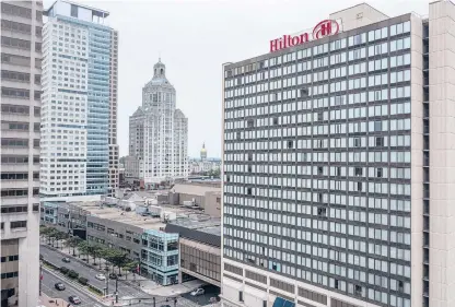  ?? MARK MIRKO/HARTFORD COURANT ?? The 22-story Hilton Hotel in downtown Hartford, right, is facing closure and could be partly converted to 147 apartments under a proposal to keep some hotel rooms open.