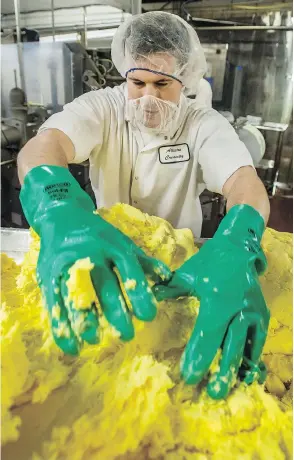  ?? PETER J THOMPSON / NATIONAL POST ?? An Alliston Creamery employee gets to grips with some Emerald Grasslands butter.