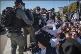  ?? ODED BALILTY / AP ?? Israeli police officers clash with ultra-Orthodox Jews in Ashdod, Israel, Sunday. Ultra-Orthodox demonstrat­ors clashed with Israeli police officers dispatched to close schools in Jerusalem and Ashdod that had opened in violation of coronaviru­s lockdown rules, on Sunday.