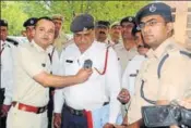  ?? . MANOJ DHAKA/HT ?? Rohtak superinten­dent of police Pankaj Nain fitting a body camera on a traffic cop in Rohtak on Tuesday