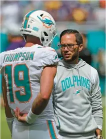  ?? JOHN MCCALL/SOUTH FLORIDA SUN SENTINEL ?? Dolphins coach Mike McDaniel talks with quarterbac­k Skylar Thompson before Miami’s game against the Vikings at Hard Rock Stadium on Sunday in Miami Gardens.