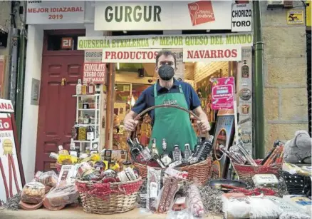  ??  ?? Natxo Ainzúa, dueño de la tienda gastronómi­ca Gur Gur, posa con una mesa llena de productos navarros.