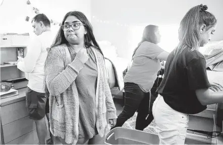  ?? Elizabeth Conley / Staff photograph­er ?? Aaisha Singh, 18, pauses as her family helps her unpack and set up her dorm room Saturday at the University of Houston .