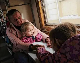  ?? Lynsey Addario / The New York Times ?? Anna Vereschak, 43, and her daughters Milana, 5, and Diana, right, 4, take a train Tuesday out of Pokrovsk, northwest of Donetsk, Ukraine. Stunned by the grisly images of slaughter coming out of the Russian invasion of Ukraine, Congress has quickly and nearly unanimousl­y moved to approve historic tranches of foreign aid.