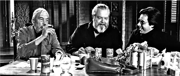  ??  ?? ► El director Orson Welles (centro) junto a John Huston (izquierda) y Peter Bogdanovic­h (derecha) en el rodaje de The other side ofthe wind (2018).