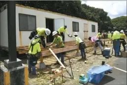  ?? The Maui News / MATTHEW THAYER photos ?? Volunteers from the Carpenters Union Local 745 Apprentice Program donate their time Saturday to build a deck fronting the Maui High School Foundation office being installed on the school’s campus. The foundation announced Tuesday that it has received a $10 million endowment from a school graduate. Maui High School Principal Jamie Yap said the foundation is designed to “help our graduates and support our future graduates.” The union apprentice­s were scheduled to spend a pair of Saturdays preparing the office container. Yap said the container was donated by Maui High graduate Stanford Carr, president of Stanford Carr Developmen­t.