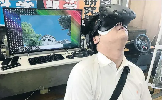  ?? HARUKA NUGA / AP ?? Namio Matsura, de 17 años, visita en realidad virtual el edificio de Hiroshima que hoy se conoce como la Cúpula de la Bomba