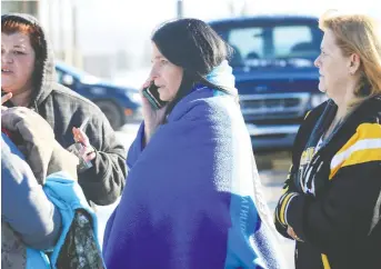  ?? NICK BRANCACCIO ?? Covered by an Essex-windsor EMS blanket, Mcgregor resident Jody Perron, centre, fled a fire at the Naples Pizza complex with her two children on Wednesday. A Gofundme campaign has been set up to benefit Perron's family.