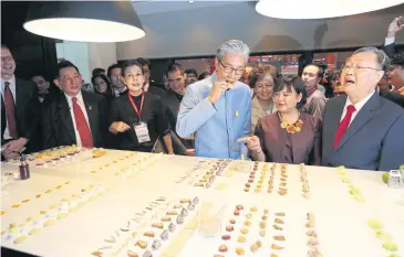  ??  ?? Deputy Prime Minister Somkid Jatusripit­ak eats a snack displayed at ThaiFex: World of Food Asia 2018.