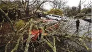  ?? KENT PORTER / THE PRESS DEMOCRAT VIA AP ?? Amber Balog surveys damage to a friend’s car, in Santa Rosa, Calif., on Tuesday, after record rainfall and high winds swept the state.