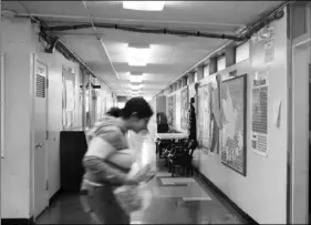  ?? AP PHOTO/JOCELYN GECKER ?? In this Jan. 27 file photo, a student walks through a hallway where bunches of electrical wires hang from the ceiling at Lake Elementary School in San Pablo, Calif.