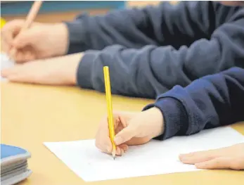  ?? FOTO: DPA ?? Schreiben auf Papier – die Grundschül­er an der Comenius-Grundschul­e in Buchloe lernen heutzutage anders das Alphabet: mithilfe einer Lern-App auf dem Tablet.