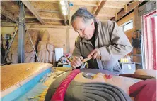  ?? ELAINE THOMPSON PHOTOS, THE ASSOCIATED PRESS ?? Lummi Nation lead carver Jewell James works on the final details of a nearly five-metre totem pole to be given to the Biden administra­tion, on Monday on the Lummi Reservatio­n, near Bellingham, Washington.