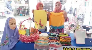  ??  ?? SALAWATI (kiri) mempamerka­n shawl instant yang dihasilkan.