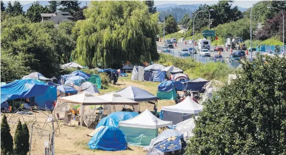  ?? DARREN STONE, TIMES COLONIST ?? The tent city in 1.35-acre Regina Park, adjacent to the Trans-Canada Highway, is occupied by dozens of campers. Campers have defied Saanich’s notices to leave.