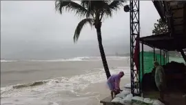  ?? (Photo Sébastien Botella) ?? À Koh Samui, jeudi, le personnel d’un hôtel donnant sur la mer dispose des sacs à sable, en prévision de l’arrivée de la tempête tropicale.