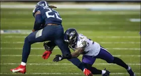  ?? BRETT CARLSEN — THE ASSOCIATED PRESS ?? Baltimore Ravens safety DeShon Elliott, right, tackles Tennessee Titans running back Derrick Henry in Sunday’s playoff game. Henry, who rushed for more than 2,000 yards during the regular season, was held to 40 by the Ravens, who won the game, 20-13.