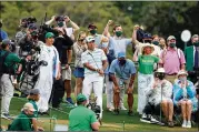  ??  ?? The gallery reacts as Hideki Matsuyama chips toward the 18th green during the third round Saturday. Matsuyama, the eventual champion, parred the hole to finish off a 7-under 65, his best round of the tournament.