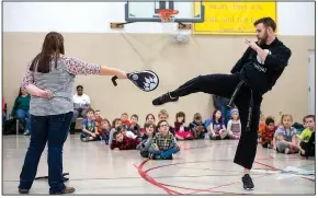  ?? NWA Democrat-Gazette/BEN GOFF • @NWABENGOFF ?? Kimberly Manley, a “team mom,” and Chandler Fordham, an instructor from Pro Martial Arts in Rogers, demonstrat­e a kick during a physical education period for kindergart­ners through second-graders during the biweekly “social day” meeting of the Social...