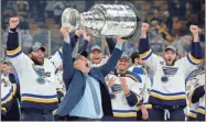  ??  ?? St. Louis Blues head coach Craig Berube carries the Stanley Cup after the Blues defeated the Boston Bruins in Game 7 of the NHL Stanley Cup Final, Wednesday in Boston.