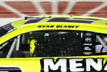  ?? Jared C. Tilton, Getty Images ?? Ryan Blaney attempts to replace his window net after a caution on the final lap and before overtime in the All-star Race on Sunday.