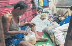  ??  ?? LEARNING TO MANAGE WITH LESS: Fernando Gonzales checks his family’s ration of statesubsi­dised rice in Manila where soaring food prices are a source of widespread discontent.