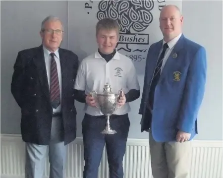  ??  ?? Champ Roddy McAuley is presented with his trophy by Derek McGlynn, president of the Renfrewshi­re Golf Union and Ian Laing, of Greenlaw Garage