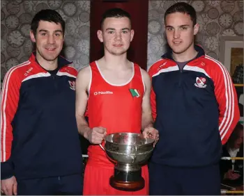  ??  ?? Conor Jordan of St. Aidan’s Boxing Club in Ferns, who was crowned All-Ireland elite boxing champion at 49 kg. recently, pictured with coaches Derek Thorpe and Tommy Dwyer.