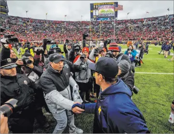  ?? Tony Ding The Associated Press ?? Ohio State coach Ryan Day, left, and Michigan’s Jim Harbaugh will get going soon. The Big Ten season starts Oct. 24.