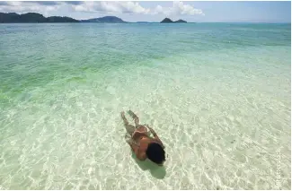  ??  ?? BOTTOM RIGHT:
Bajau boy swimming in shallow water