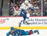  ?? JOHN LOCHER/AP ?? Lightning center Steven Stamkos (91) jumps over Avs defenseman Erik Johnson during Game 1. Game 2 was not finished in time for this edition.