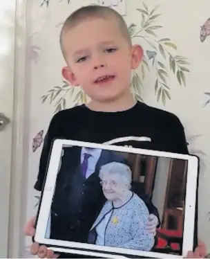  ??  ?? ●●Six-year-old James Cochrane with a picture of his great-grandmothe­r in a still from the video.