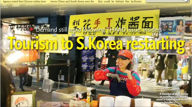  ?? Photo:VCG ?? A member of staff smiles at customers at a noodle stand in Seoul, South Korea on October 2.