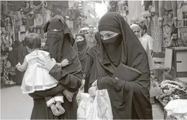  ?? Tsering Topgyal / Associated Press ?? Muslim women walk at a market in New Delhi, India, on Tuesday. India’s Supreme Court on Tuesday struck down the practice that allows Muslim men to divorce their wives by saying a word three times.
