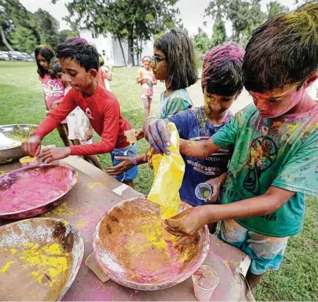 ?? Michael Wyke / Contributo­r ?? Elementary- and middle-school-aged campers, covered with colored powder, refill their cups during the Holi Festival celebratio­n at the Hindu Heritage Youth Camp in 2019 at Camp Lantern Creek near Montgomery. Camp will resume in person this summer.
