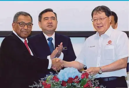  ?? PIC BY MOHAMAD SHAHRIL BADRI SAALI ?? Johor Port Authority chairman Rosnan Fathlal (left) exchanging documents with Smart Crest Sdn Bhd managing director Cher Lee Kiat at a signing ceremony for the ‘Bunker Island’ project yesterday, witnessed by Transport Minister Anthony Loke Siew Fook.