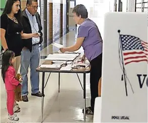  ??  ?? Una pareja de latinos emiten su voto temprano