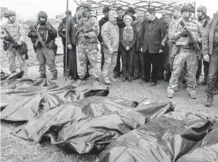  ?? EFREM LUKATSKY AP ?? EU Commission President Ursula von der Leyen, center, looks at covered bodies of killed civilians in Bucha, on the outskirts of Kyiv, Ukraine, on Friday.