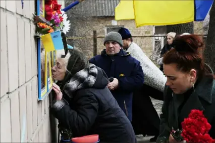  ?? Thibault Camus/Associated Press ?? Anna Levchenko, 81, kisses the picture of her grandson Andrii Matviichuk, during a gathering Saturday to mark the first anniversar­y of the death of eight men killed by Russian forces in Bucha, Ukraine. The eight had set up a roadblock in the town in an attempt to prevent Russian troops from advancing as they swept toward the Ukrainian capital at the start of their invasion.