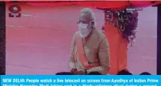  ??  ?? NEW DELHI: People watch a live telecast on screen from Ayodhya of Indian Prime Minister Narendra Modi taking part in a Hindu religious ritual during a groundbrea­king ceremony of the Ram Temple yesterday. — AFP