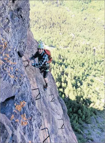  ?? JOSHUA BUTSON/FOR THE WASHINGTON POST ?? John Briley on the most exposed section of the Telluride via ferrata, which features artificial handholds and footholds.