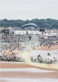  ??  ?? A member of The Tiger parachute display team drops on to Seaburn beach.