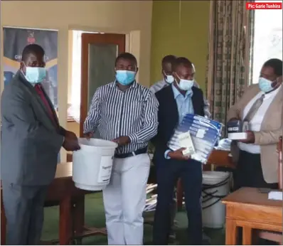  ?? Pic: Garie Tunhira ?? ZADHR executive director Calvin Fambirai (second from left) hands over a water bucket to Gweru City Council health committee chairperso­n John Manyundwa at Town House on Friday