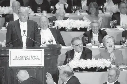  ?? SPENCER PLATT/GETTY IMAGES ?? Hillary Clinton laughs as Donald Trump speaks at the annual Alfred E. Smith Memorial Foundation Dinner, which benefits Catholic charities, at the Waldorf Astoria on Oct. 20 in New York City.